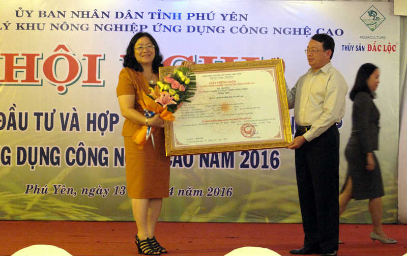 Chủ tịch UBND tỉnh Phú Yên Hoàng Văn Trà trao Giấy chứng nhận cho bà Nguyễn Thị Nga về những hiệu quả ứng dụng khoa học công nghệ trong ươm giống, nuôi trồng thủy sản.